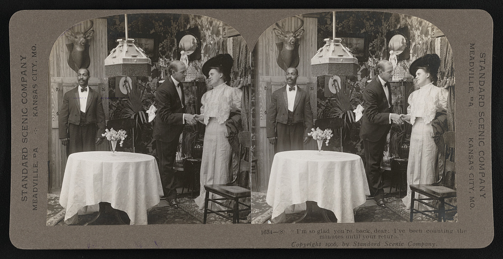 Stereoscope slide shows dumwaiter in use in Victorian household. Server is placed behind guests, almost hidden from the scene. 