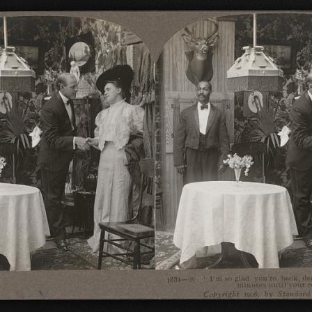 Stereoscope slide shows dumwaiter in use in Victorian household. Server is placed behind guests, almost hidden from the scene. 